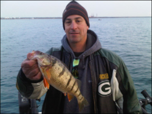 man holding fish on lake michigan